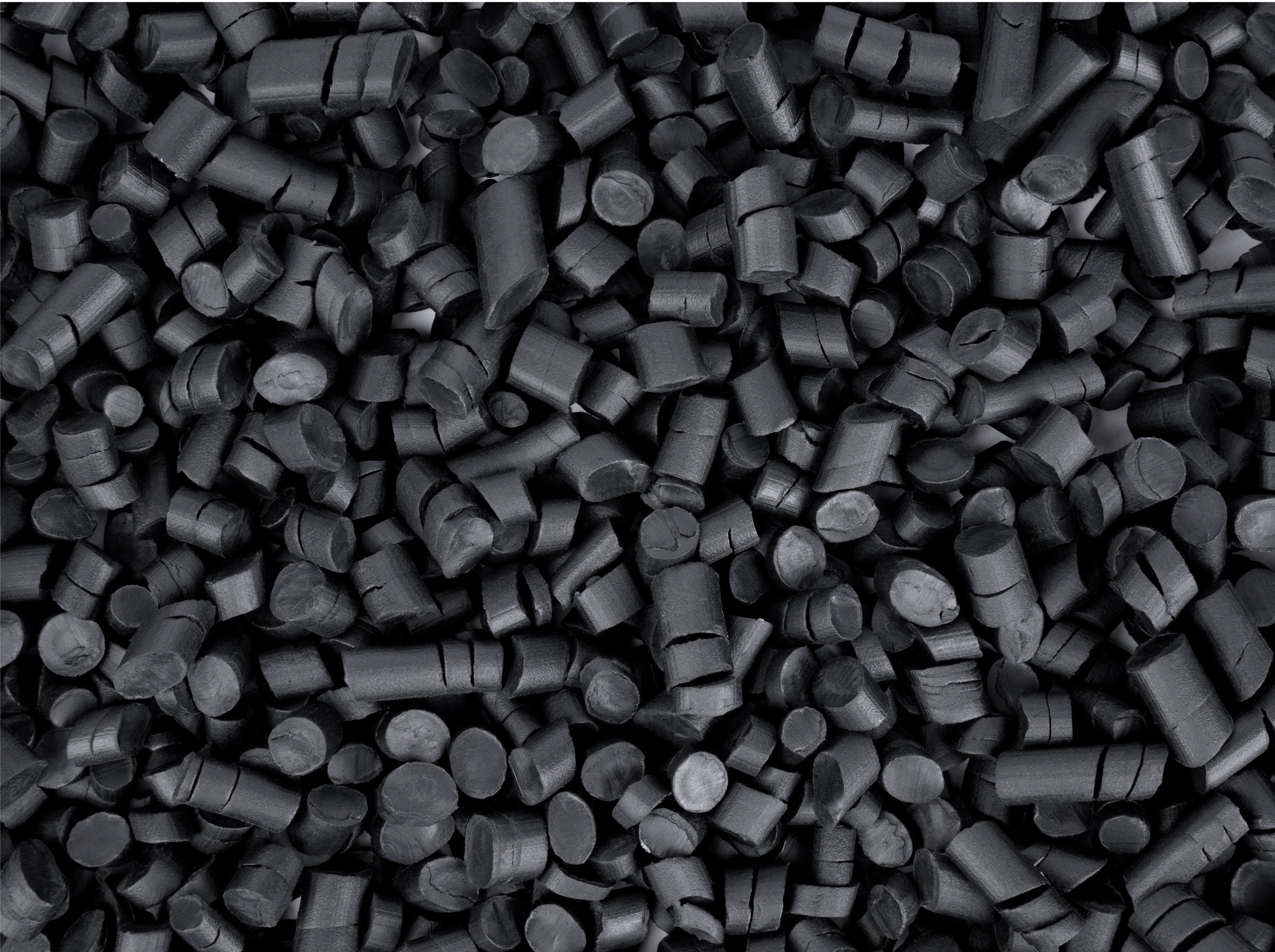 Close-up of black plastic pellets used in manufacturing