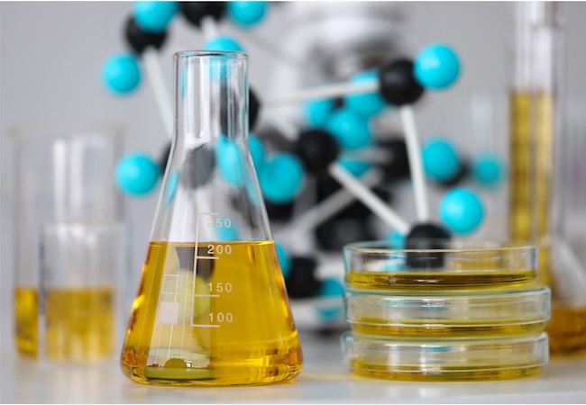 Laboratory glassware containing yellow liquid on a lab bench