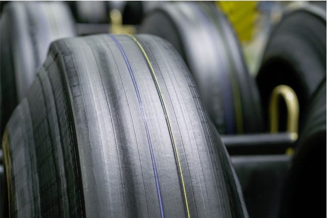 Large rolls of black rubber material in a factory