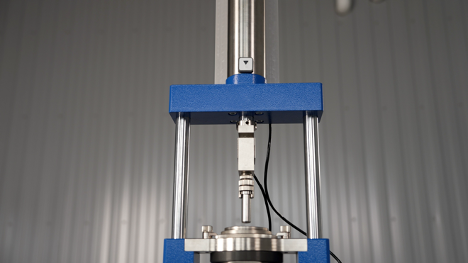Laboratory compression testing machine with mounted sample fixture