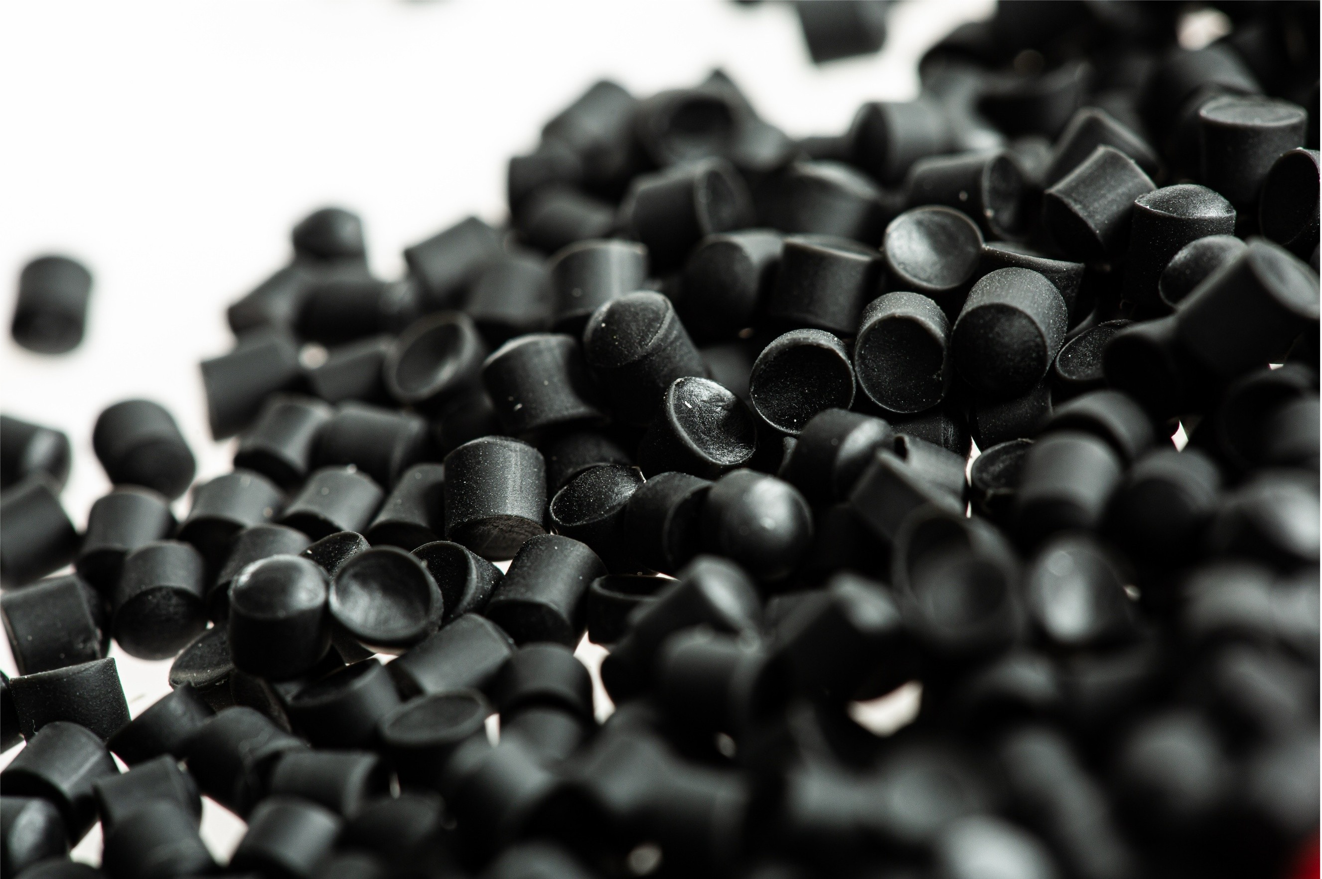 Close-up of black rubber caps scattered on a white surface