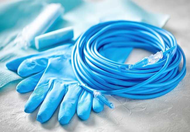 Blue medical tubing and disposable gloves on a white surface