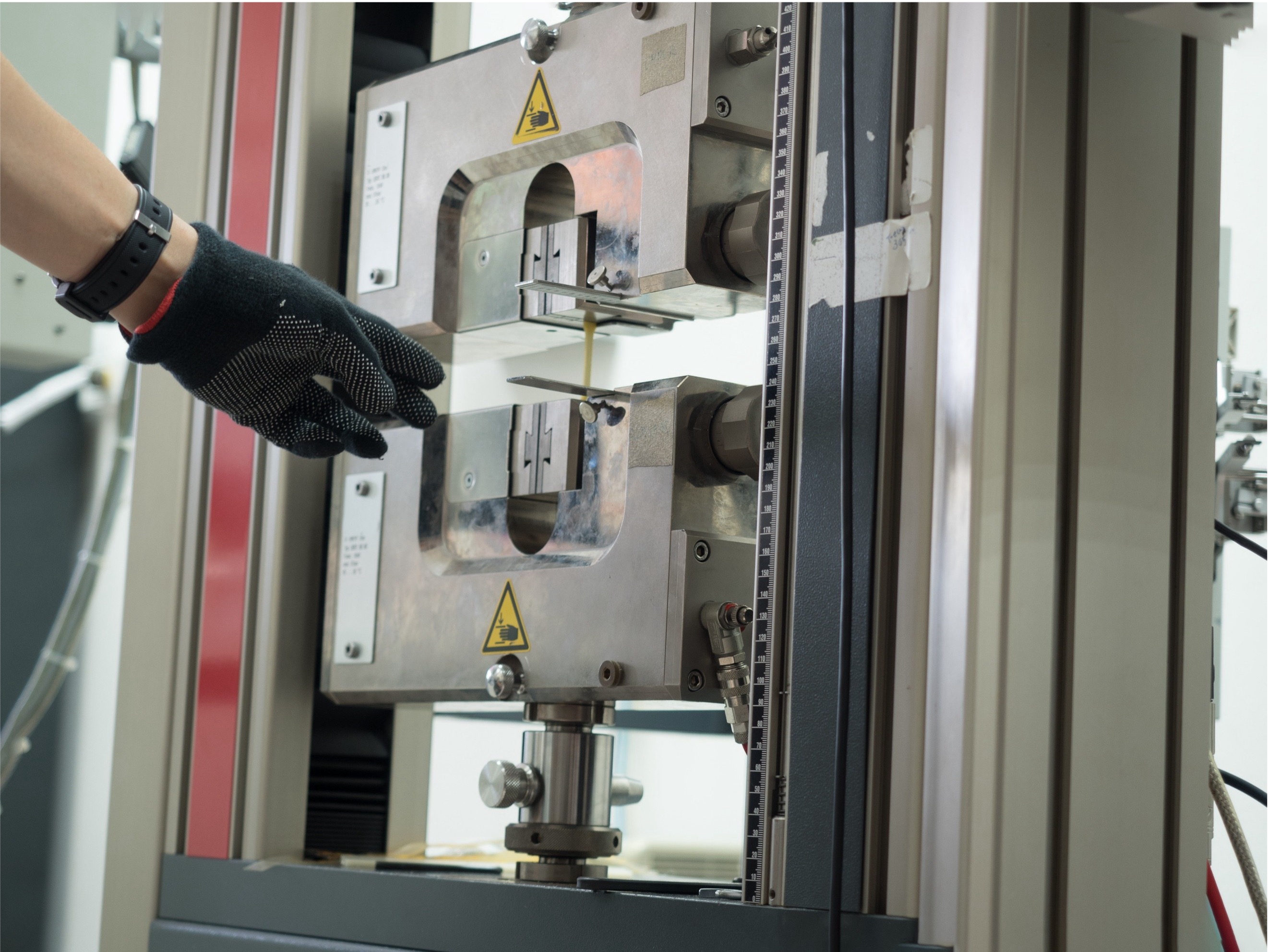 Technician operating a material testing machine in a laboratory
