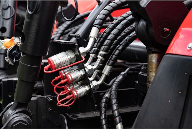 Close-up of hydraulic hoses and mechanical components on industrial equipment