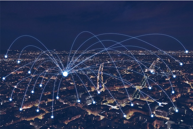 City skyline at night with digital network connection lines