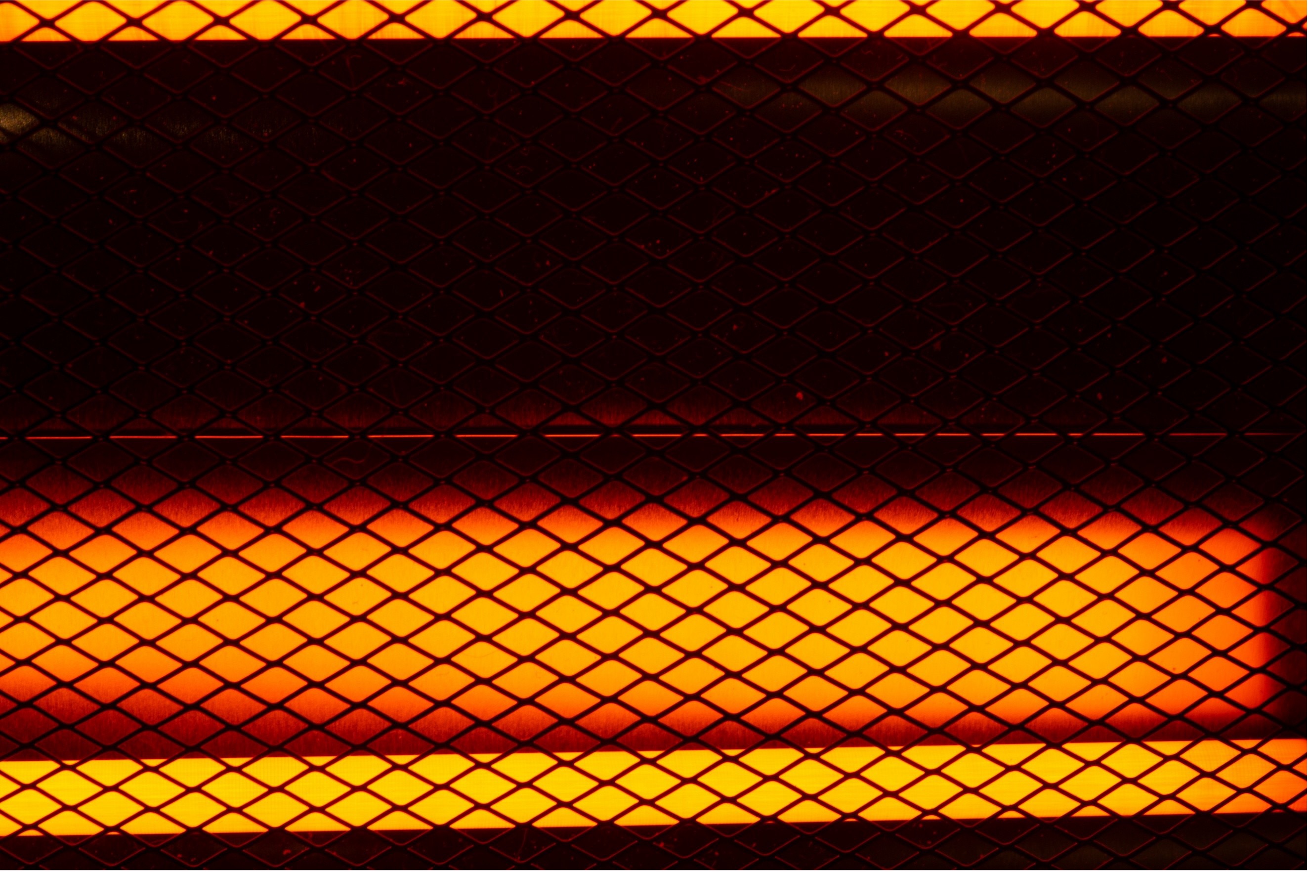 Glowing orange heating element behind a metal mesh screen.