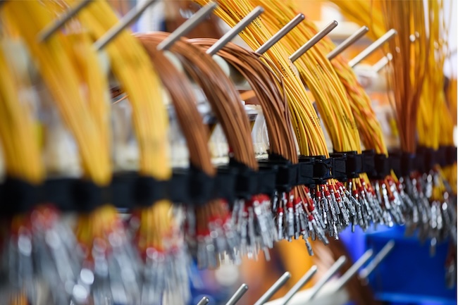 Bundles of electrical wires hanging in a manufacturing setting